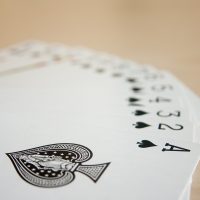 空中接龙扑克牌游戏内容维护者青禾在电脑前核对页面文字，屏幕上显示整理中的条目列表，桌面整洁，专注校对的工作状态