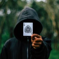 空中接龙扑克牌游戏编辑阿禾整理桌面上的牌局记录卡片，旁边摊着笔记本与彩色便签，傍晚暖光透过窗帘，编辑工作场景